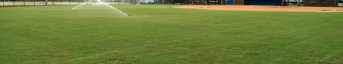 athletic field with sprinklers active
