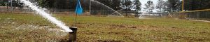 athletic fields with sprinklers activated
